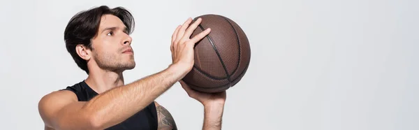 Morena desportista sem mangas camisa segurando bola de basquete isolado em cinza, banner — Fotografia de Stock