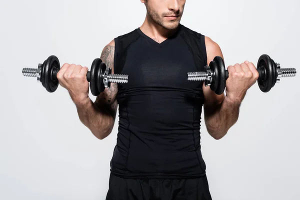 Cropped view of athletic sportsman training with dumbbells isolated on grey — Foto stock