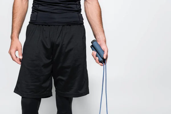 Cropped view of sportsman holding jump rope isolated on grey — Stock Photo