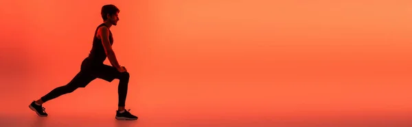 Вид сбоку на тренировку Мбаппе на красном фоне с копировальным пространством, баннер — стоковое фото