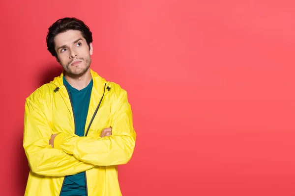 Pensive sportsman crossing arms on red background — Stock Photo