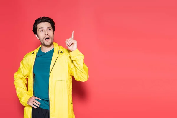 Shocked sportsman in sportswear having idea on red background — Stock Photo