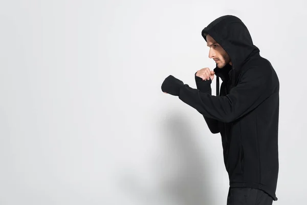 Vista lateral do lutador em jaqueta de esportes em pé sobre fundo cinza — Fotografia de Stock