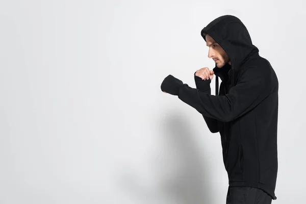 Side view of fighter in sports jacket standing on grey background — Foto stock