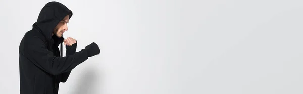 Vue latérale du combattant en veste de sport regardant loin sur fond gris, bannière — Photo de stock