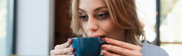 Young blonde woman drinking coffee in restaurant, banner — Stockfoto