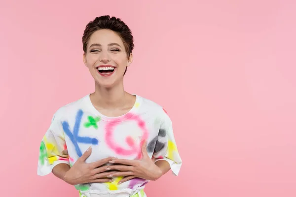 Excited brunette woman laughing while looking at camera isolated on pink — Stockfoto