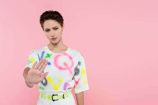 Mujer frustrada mostrando señal de stop mientras mira la cámara aislada en rosa - foto de stock