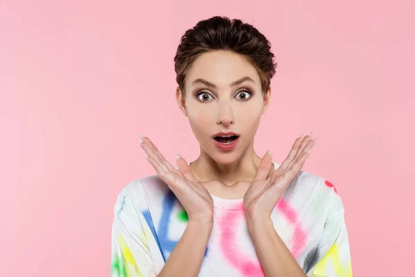 Astonished woman with open mouth holding hands near face while looking at camera isolated on pink — Stockfoto