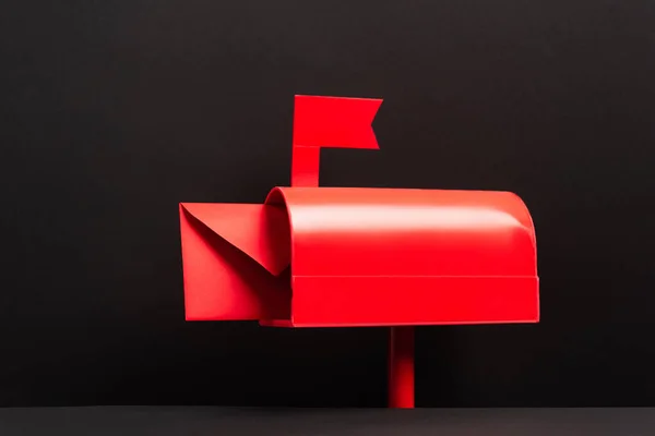 Red envelope in metallic post box on black — Stockfoto