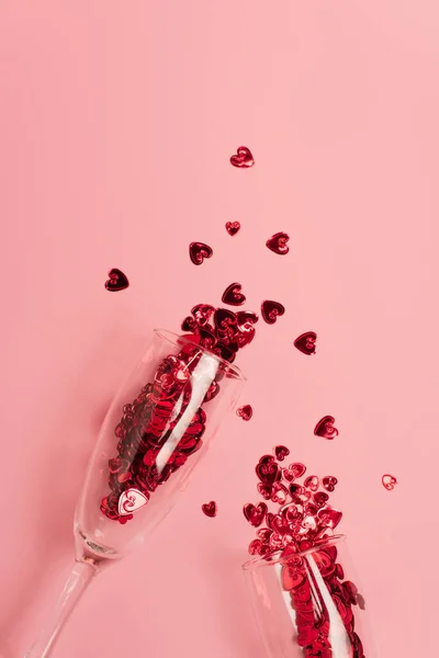Top view of champagne glasses with confetti hearts on pink — Stockfoto