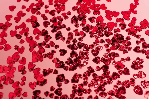 Vue de dessus des cœurs de confettis rouges brillants sur rose — Photo de stock