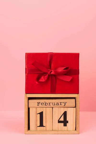 Coffret cadeau rouge sur cubes en bois avec lettrage 14 février sur rose — Photo de stock