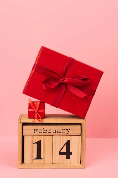 Red gift boxes on wooden cubes with 14 february lettering on pink — Fotografia de Stock