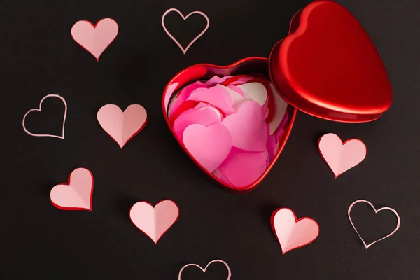 Верхний вид розовой бумаги сердца в металлической коробке на черном — стоковое фото