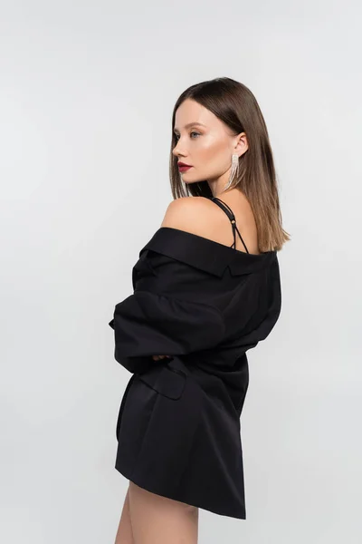 Sexy brünette Frau im schwarzen Blazer posiert isoliert auf grau — Stockfoto