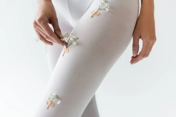 Partial view of slim woman with small flowers on tights isolated on light grey — Stock Photo