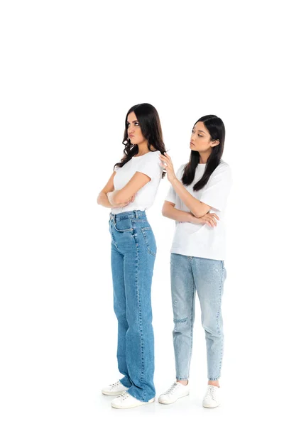 Full length view of offended woman standing with crossed arms near asian friend on white — Fotografia de Stock