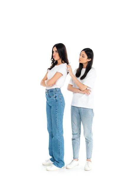 Longitud completa vista de ofendido mujer de pie con cruzados brazos cerca asiático amigo en blanco - foto de stock