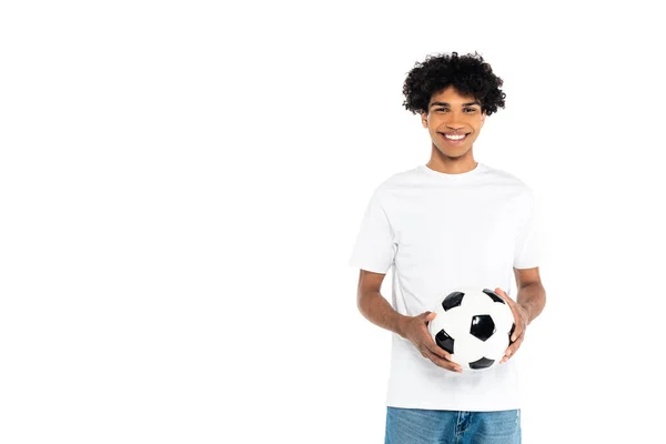 Pleased african american man holding soccer ball while looking at camera isolated on white — стоковое фото