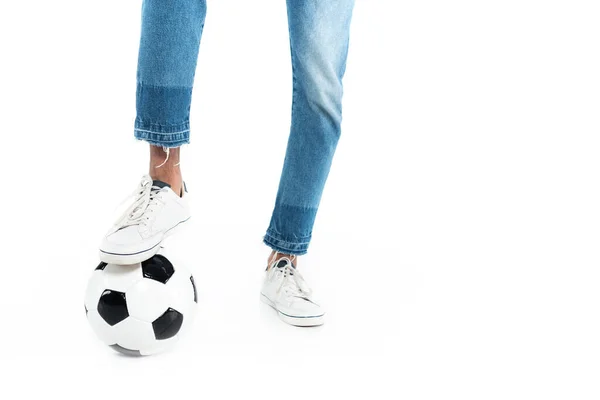 Vue partielle de l'homme afro-américain en baskets et jeans jouant au football sur blanc — Photo de stock