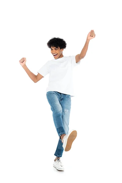 Full length view of african american man in jeans and t-shirt dancing on white — стоковое фото