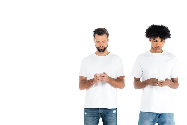 Uomini multietnici in t-shirt che chattano sui telefoni cellulari isolati su bianco — Foto stock
