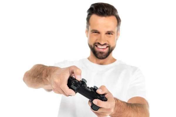 KYIV, UCRAINA - 5 DICEMBRE 2021: uomo sfocato sorridente mentre gioca con joystick isolato sul bianco — Foto stock