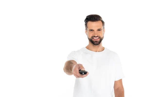 Cheerful man clicking channels on tv remote controller isolated on white — Stock Photo