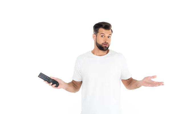 Confused man with tv remote controller showing shrug gesture isolated on white — Stock Photo