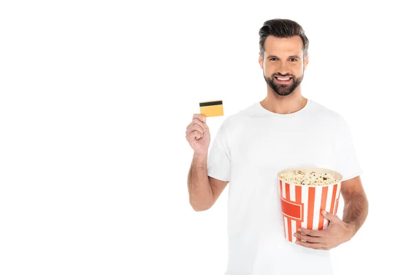Man with big bucket of popcorn and credit card smiling at camera isolated on white — Stock Photo