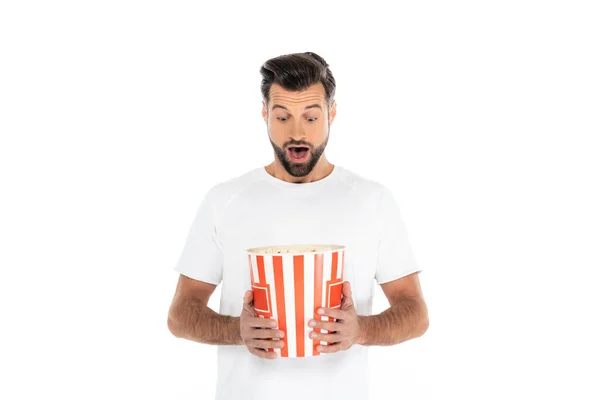 Amazed man looking at big bucket of popcorn isolated on white — Stock Photo