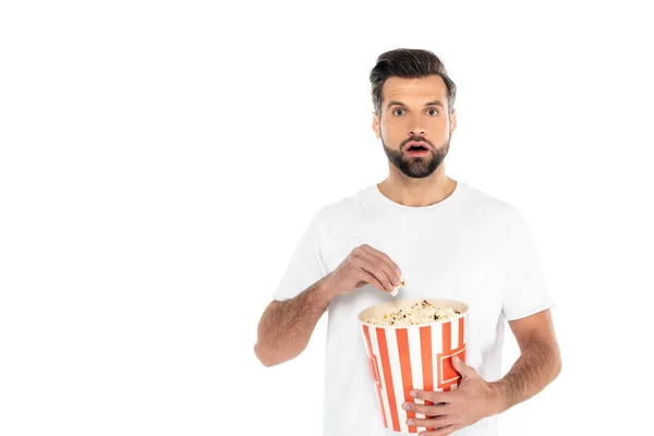 Erstaunter Mann sieht Film und isst Popcorn isoliert auf weißem Grund — Stockfoto