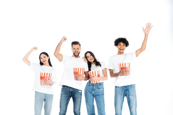 Sorridente afroamericano mano agitando vicino amici eccitati con popcorn mostrando vincere gesto isolato su bianco — Foto stock