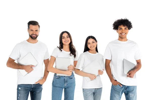 Feliz multiétnicos hombres y mujeres con computadoras portátiles sonriendo a la cámara aislada en blanco - foto de stock