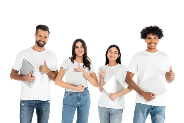 Joyeuses personnes multiculturelles avec des ordinateurs portables montrant pouces isolés sur blanc — Photo de stock