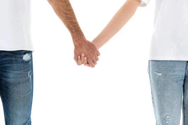 Vue recadrée du couple en jeans tenant les mains isolées sur blanc — Photo de stock