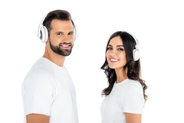 Freudiges Paar mit Kopfhörern blickt isoliert auf weiße Kamera — Stockfoto