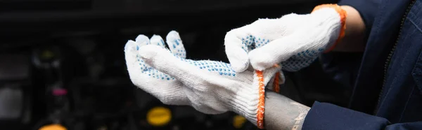 Cropped view of tattooed mechanic wearing gloves in garage, banner — Stock Photo