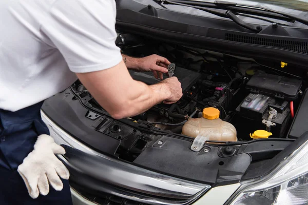 Cropped view of mechanic working with auto in garage — Fotografia de Stock