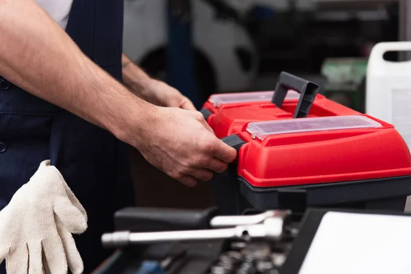 Cropped view of mechanic unlocking toolbox in garage — Stock Photo