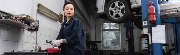 Giovane donna di fronte in possesso di strumento vicino auto in servizio, banner — Foto stock