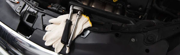 Top view of gloves and tools on car in garage, banner — Stock Photo