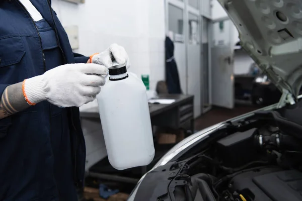 Ausgeschnittene Ansicht tätowierter Arbeiterin mit Kanister im Auto-Service — Stockfoto