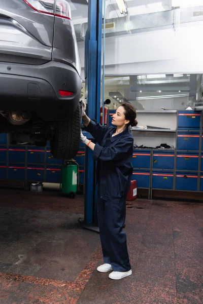 Mechanic setting disk on wheel of car in service — Stock Photo