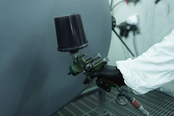 Cropped view of workman in glove holding aerograph near car part in service — Stock Photo