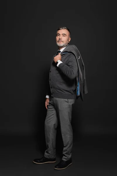 Full length view of senior confident man in stylish clothes standing on grey — Fotografia de Stock