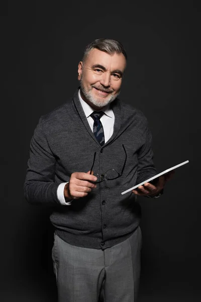 Stylish senior man with eyeglasses and digital tablet looking at camera on dark grey — Foto stock