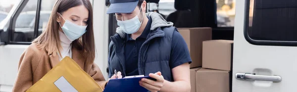 Courier in medical mask holding clipboard near woman with parcel outdoors, banner — Photo de stock