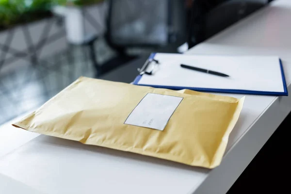 Parcel and blurred clipboard on reception in office — Fotografia de Stock